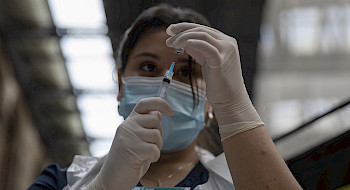 Foto de una mujer con una jeringa y una vacuna