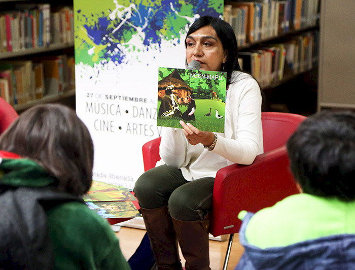 Maria Lara reading a book to children in a library