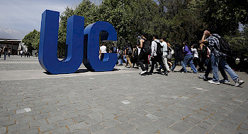 personas caminando al lado de dos letras grandes: U y C