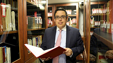 Professor Adolfo Wegmann amidst shelves full of books