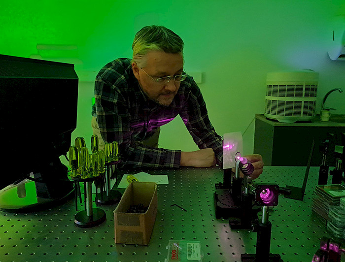 Profesor Birger Seifert trabajando con equipo óptico.