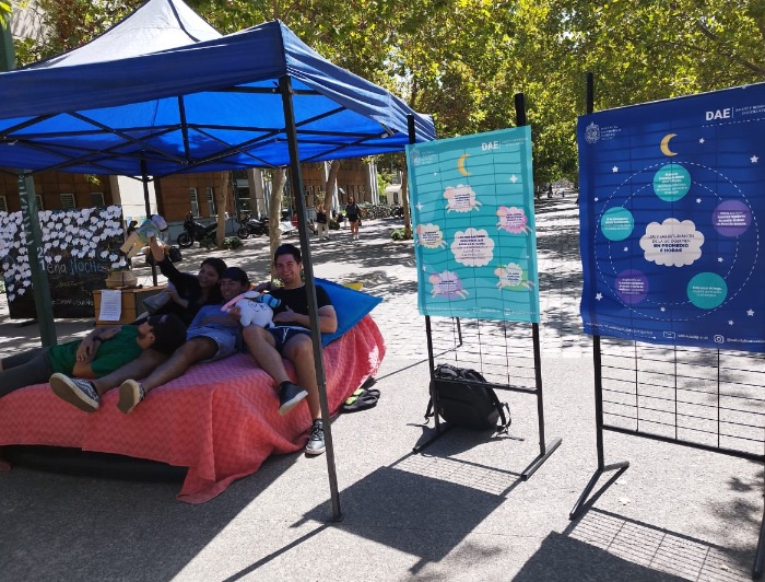 Estudiantes recostados en una cama instalada en el patio de Campus San Joaquín, como parte de una campaña para concientizar sobre la importancia de dormir bien. 
