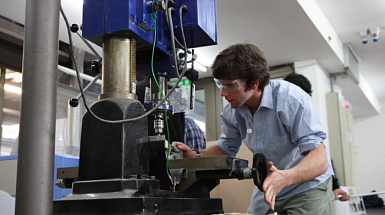 Estudiante utilizando máquina, en el marco del desarrollo científico, tecnológico y de innovación en la UC.