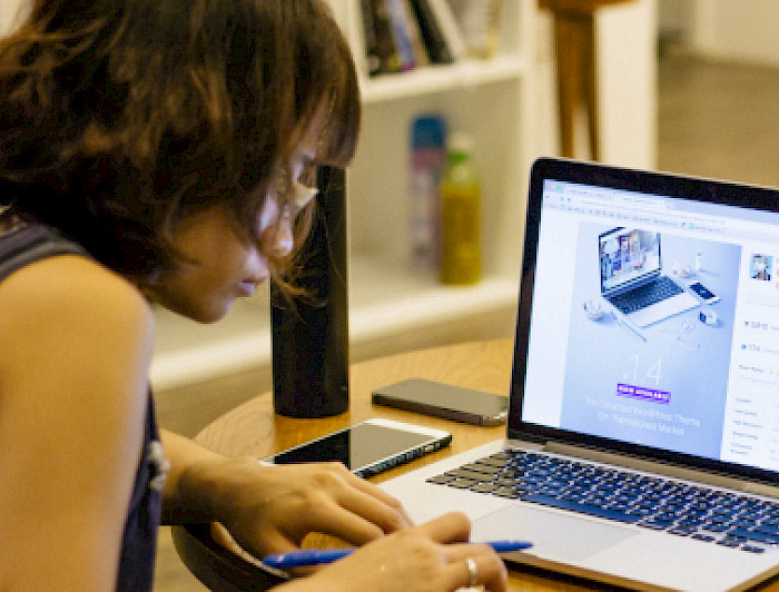 Mujer estudiantdo frente a la pantalla de un computador.