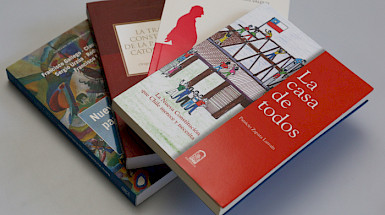 Libros de Ediciones UC acerca de la Constitución desplegados sobre una mesa.