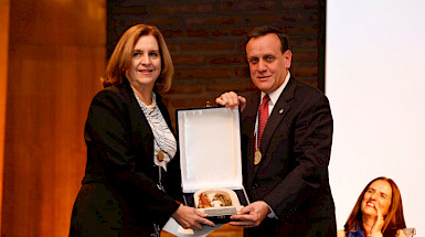 La profesora Silvia Pellegrini recibe el premio Monseñor Carlos Casanueva de parte del rector Ignacio Sánchez.